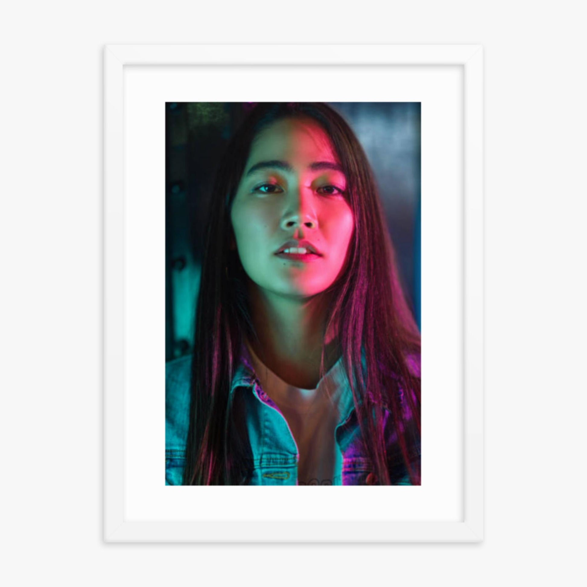 Portrait of young woman lit by colorful neon lights at night 18x24 in Poster With White Frame